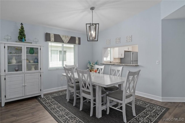 dining room with baseboards, an inviting chandelier, and dark wood-style floors