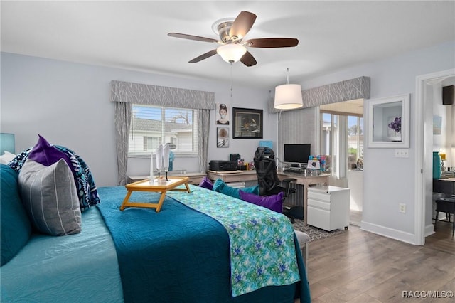 bedroom featuring baseboards, ceiling fan, and wood finished floors