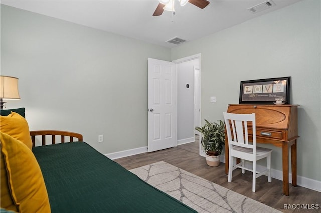 bedroom featuring baseboards, visible vents, a ceiling fan, and wood finished floors