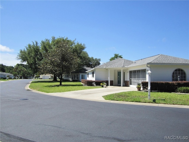 single story home with driveway, a shingled roof, a front yard, and a garage