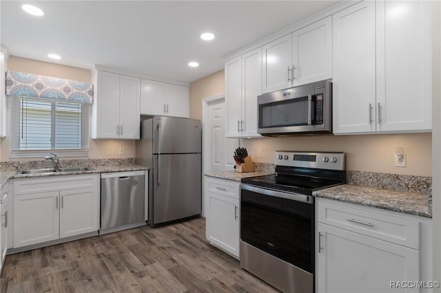 13618 SW 111th Cir, Dunnellon, FL 34432 - kitchen with appliances with stainless steel finishes, a sink, white cabinetry, wood finished floors, and recessed lighting