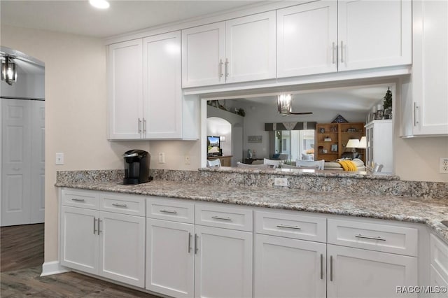 13618 SW 111th Cir, Dunnellon, FL 34432 - kitchen with arched walkways, white cabinetry, dark wood-type flooring, light stone countertops, and recessed lighting