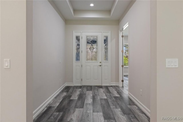 foyer entrance featuring recessed lighting, baseboards, dark wood-type flooring, and a raised ceiling