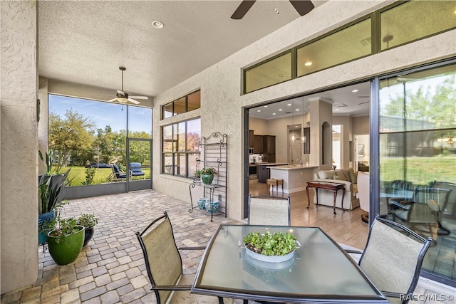 sunroom / solarium featuring a wealth of natural light and ceiling fan