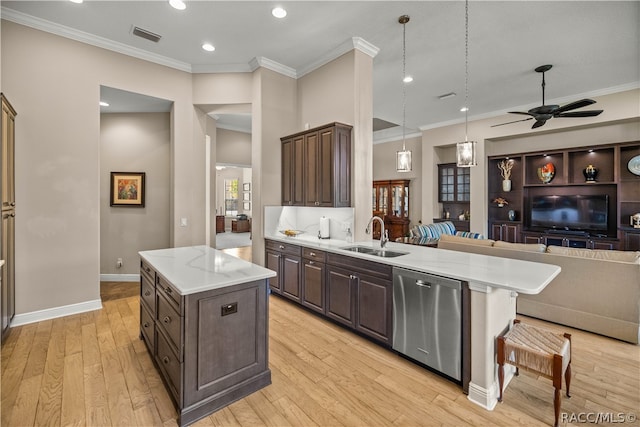 kitchen featuring light wood-type flooring, stainless steel dishwasher, a kitchen island, and sink