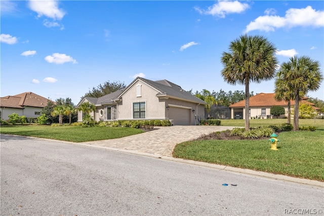 single story home featuring a garage and a front yard