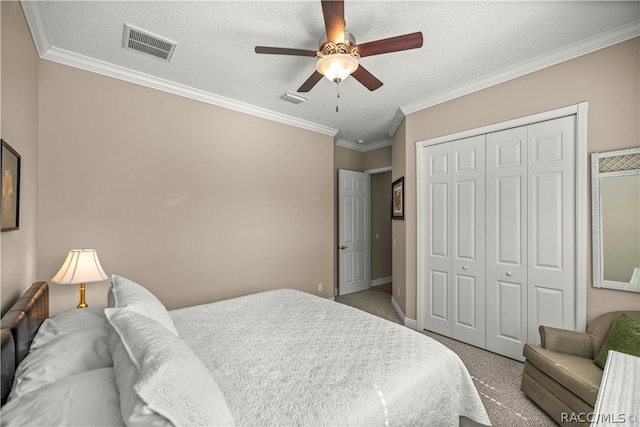 carpeted bedroom featuring ceiling fan, ornamental molding, a textured ceiling, and a closet