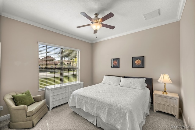 bedroom featuring ceiling fan, light colored carpet, a textured ceiling, and crown molding