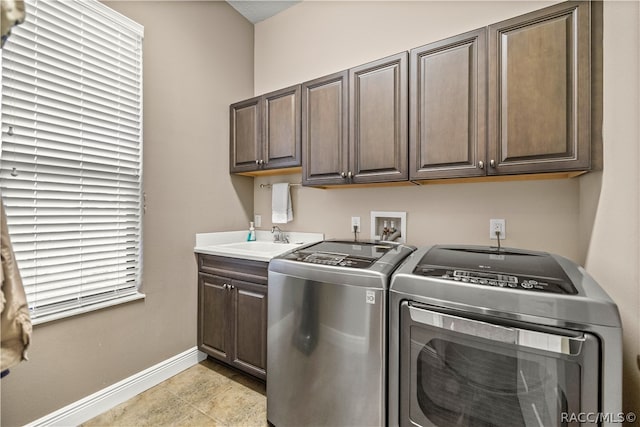 laundry area featuring cabinets, light tile patterned floors, sink, and washing machine and clothes dryer