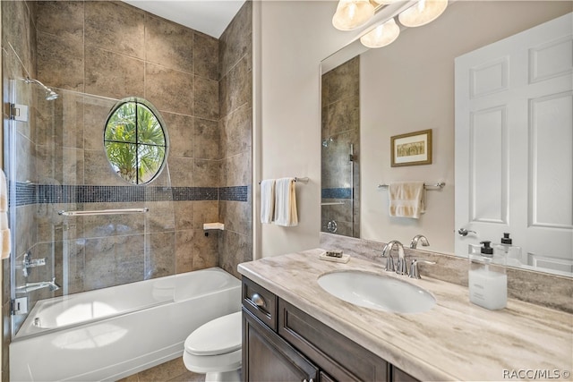 full bathroom with tiled shower / bath combo, toilet, and vanity