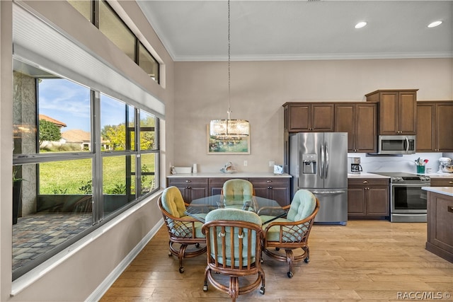 dining space featuring a chandelier, light hardwood / wood-style floors, and ornamental molding