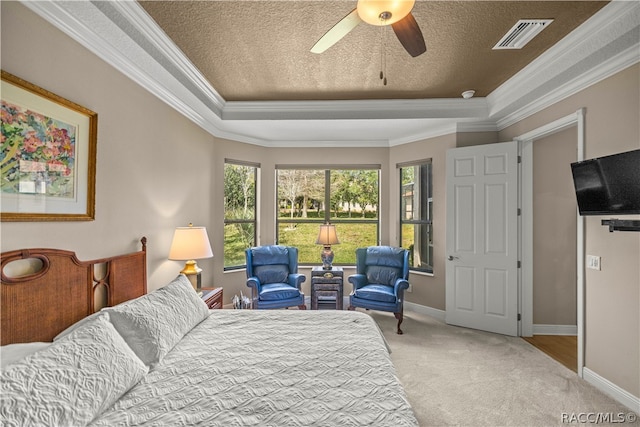 bedroom featuring a raised ceiling, crown molding, ceiling fan, a textured ceiling, and light colored carpet