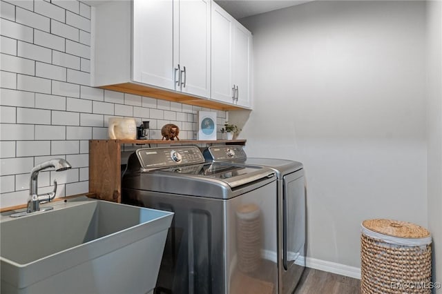 washroom with cabinets, separate washer and dryer, sink, and hardwood / wood-style floors