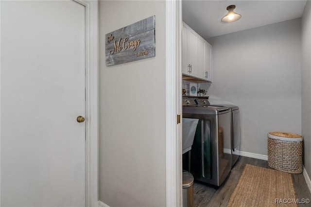 laundry room featuring dark wood-type flooring, cabinets, and washing machine and clothes dryer