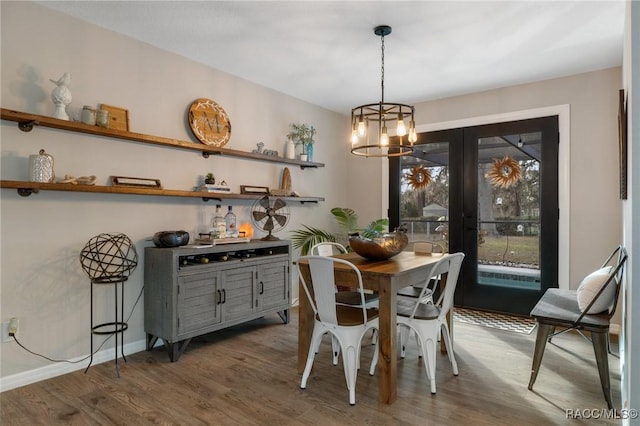 dining room with dark wood-type flooring and an inviting chandelier