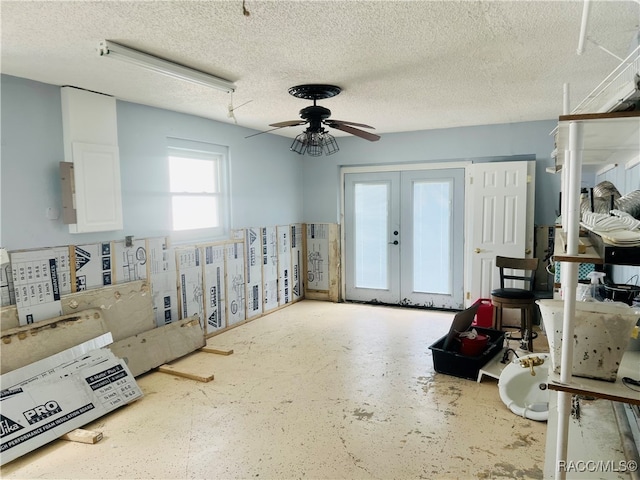 miscellaneous room with ceiling fan, french doors, and a textured ceiling