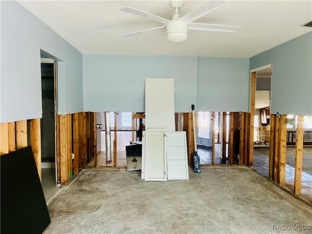 empty room with ceiling fan and wooden walls