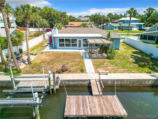 rear view of house with a lawn and a water view