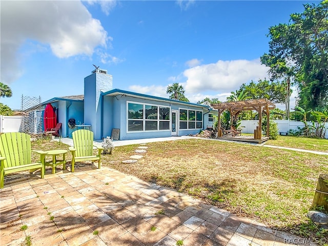 rear view of property with a pergola, a sunroom, a yard, and a patio