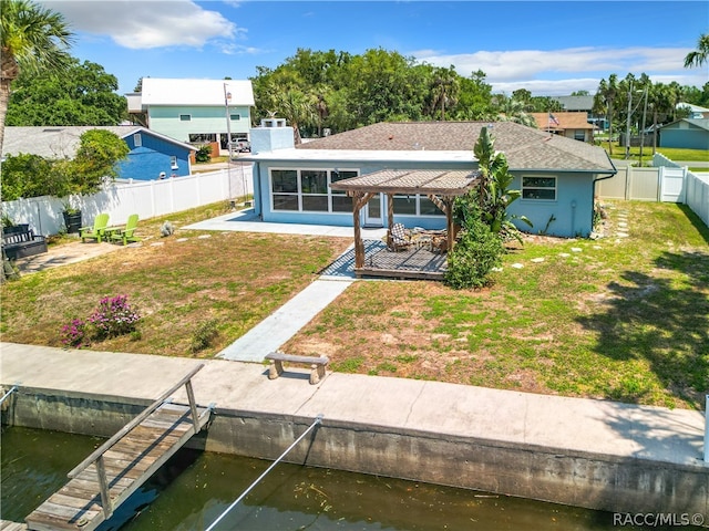 back of property with a gazebo, a sunroom, a water view, and a lawn