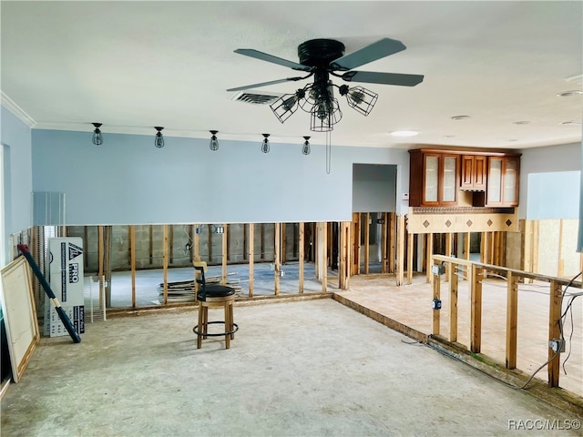 miscellaneous room featuring ceiling fan, concrete flooring, and ornamental molding