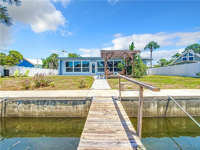 dock area with a pergola, a yard, and a water view