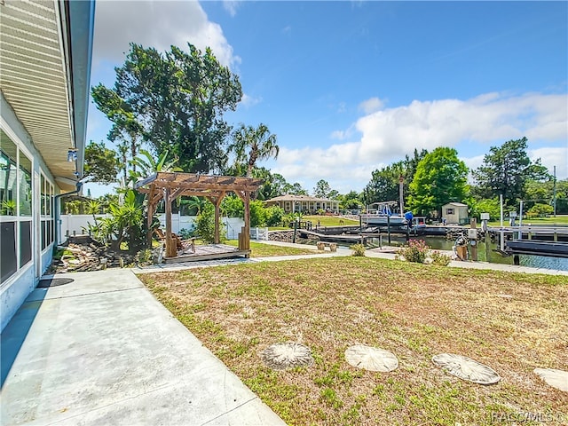 view of yard with a pergola, a dock, and a water view