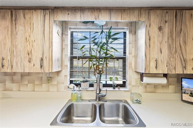 kitchen featuring tasteful backsplash and sink