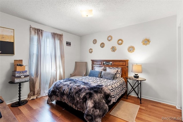 bedroom featuring hardwood / wood-style flooring and a textured ceiling