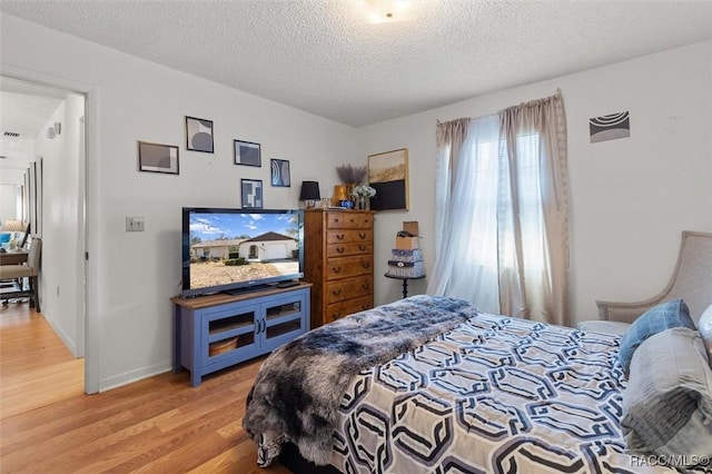 bedroom with a textured ceiling and hardwood / wood-style flooring