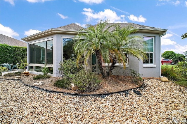view of home's exterior featuring stucco siding and a sunroom