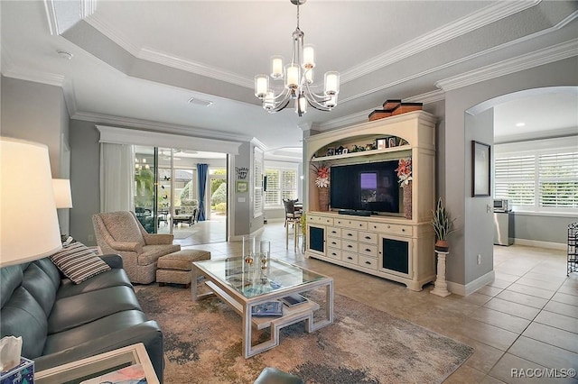 living area featuring an inviting chandelier, visible vents, baseboards, arched walkways, and light tile patterned floors