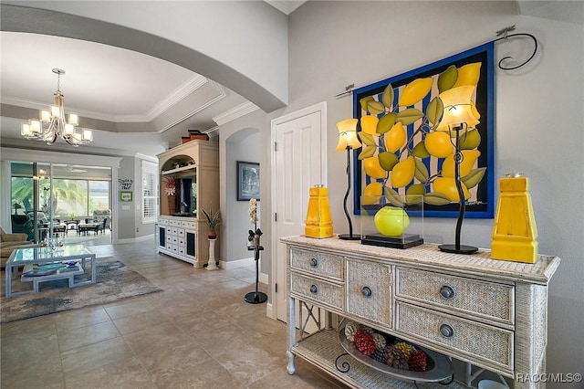 hall with an inviting chandelier, tile patterned flooring, arched walkways, baseboards, and ornamental molding