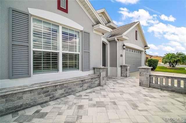 view of patio / terrace featuring a garage and driveway