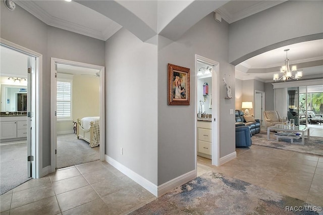 hallway with crown molding, baseboards, and a wealth of natural light