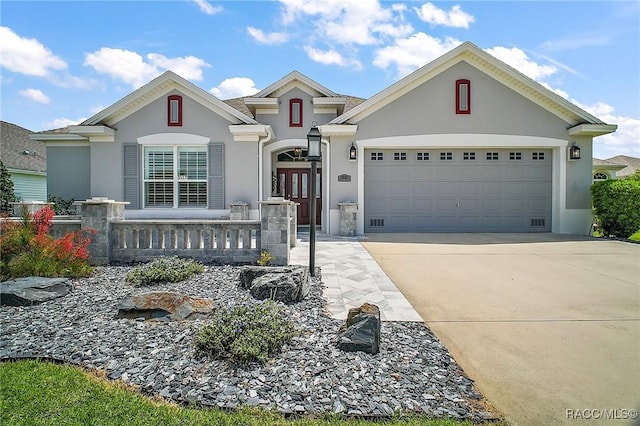 view of front facade featuring a garage, stucco siding, and driveway