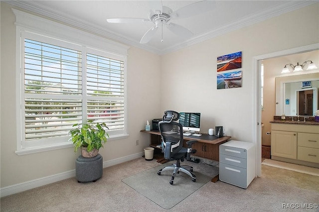 office area with crown molding, a ceiling fan, light colored carpet, and a healthy amount of sunlight