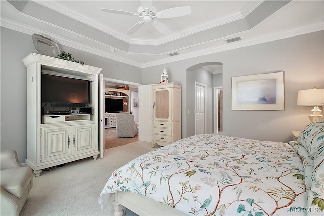 bedroom with crown molding, visible vents, light carpet, a raised ceiling, and arched walkways