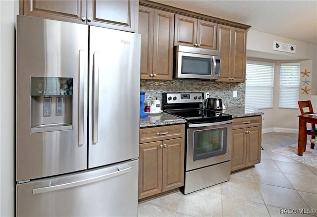 2101 N Brentwood Cir, Lecanto, FL 34461 - kitchen with appliances with stainless steel finishes, stone counters, baseboards, decorative backsplash, and light tile patterned flooring