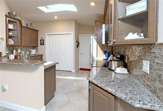 2101 N Brentwood Cir, Lecanto, FL 34461 - kitchen featuring a skylight, backsplash, light stone countertops, open shelves, and recessed lighting