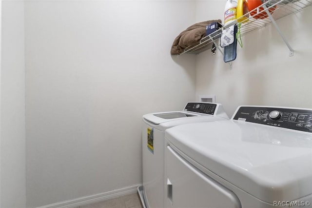 washroom featuring washer and dryer, laundry area, baseboards, and light tile patterned floors