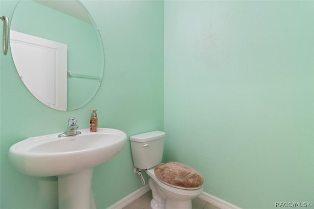 bathroom featuring sink, tile patterned flooring, and toilet