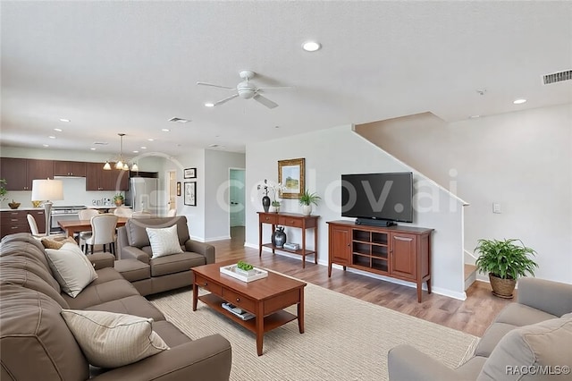 living area with light wood finished floors, visible vents, and recessed lighting