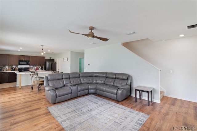 living room featuring light hardwood / wood-style floors and ceiling fan