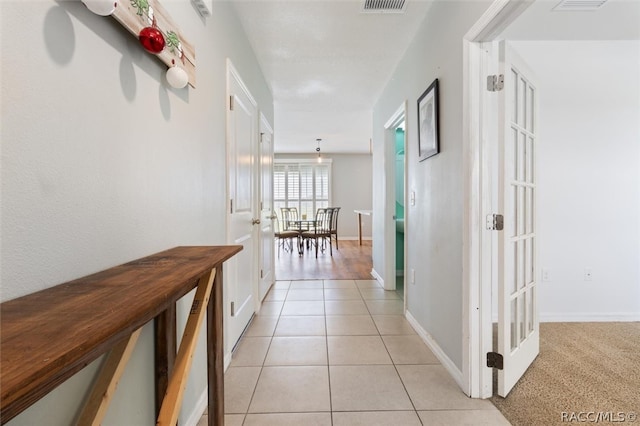 hallway with light tile patterned floors and french doors