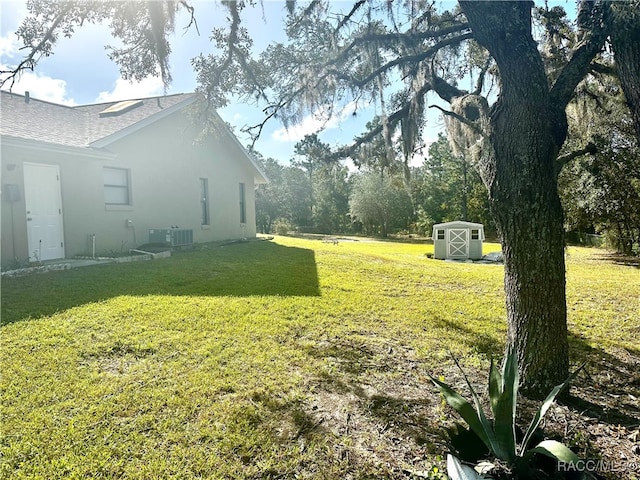 view of yard featuring a storage shed and central air condition unit