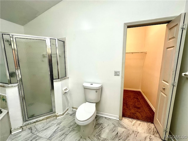 bathroom featuring toilet, a shower with shower door, and vaulted ceiling