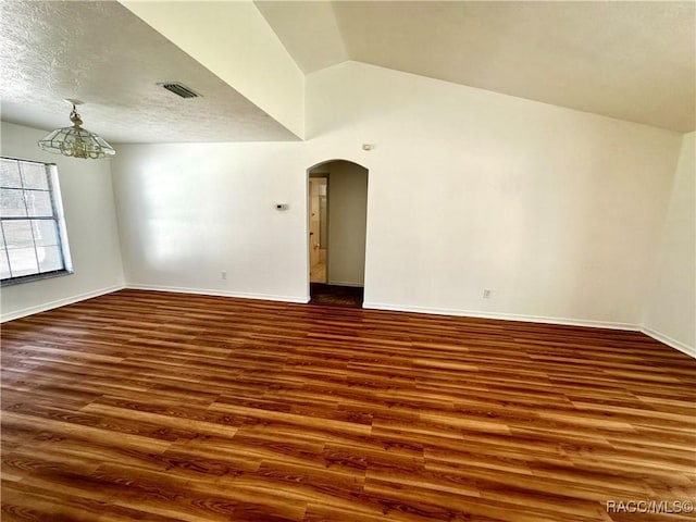 3150 W Mustang Blvd, Beverly Hills, FL 34465 - empty room featuring wood finished floors, arched walkways, baseboards, and vaulted ceiling