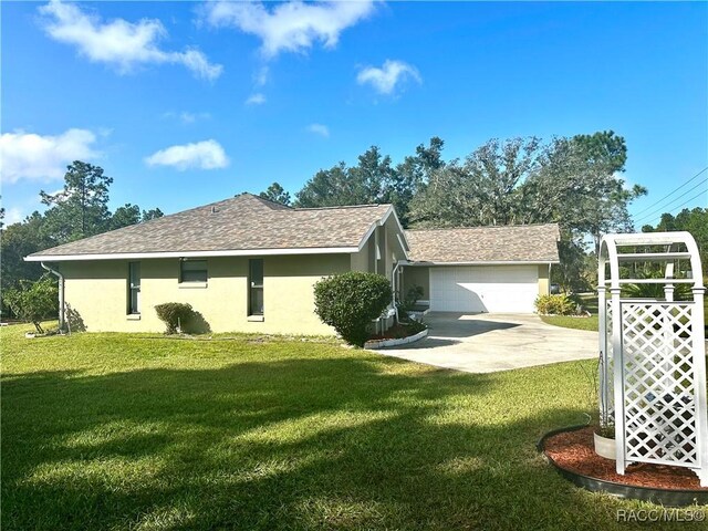 3150 W Mustang Blvd, Beverly Hills, FL 34465 - view of side of property with stucco siding, a yard, concrete driveway, and an attached garage