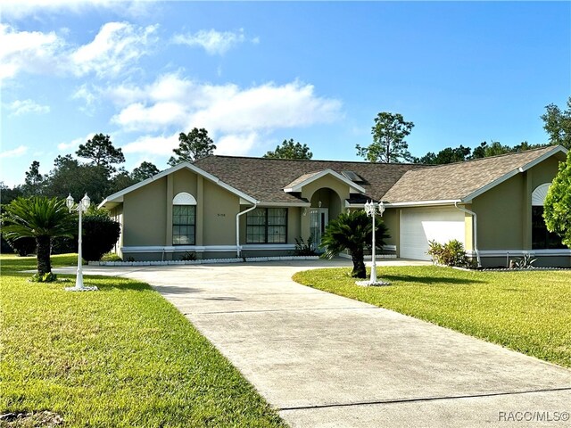 single story home with a garage and a front lawn